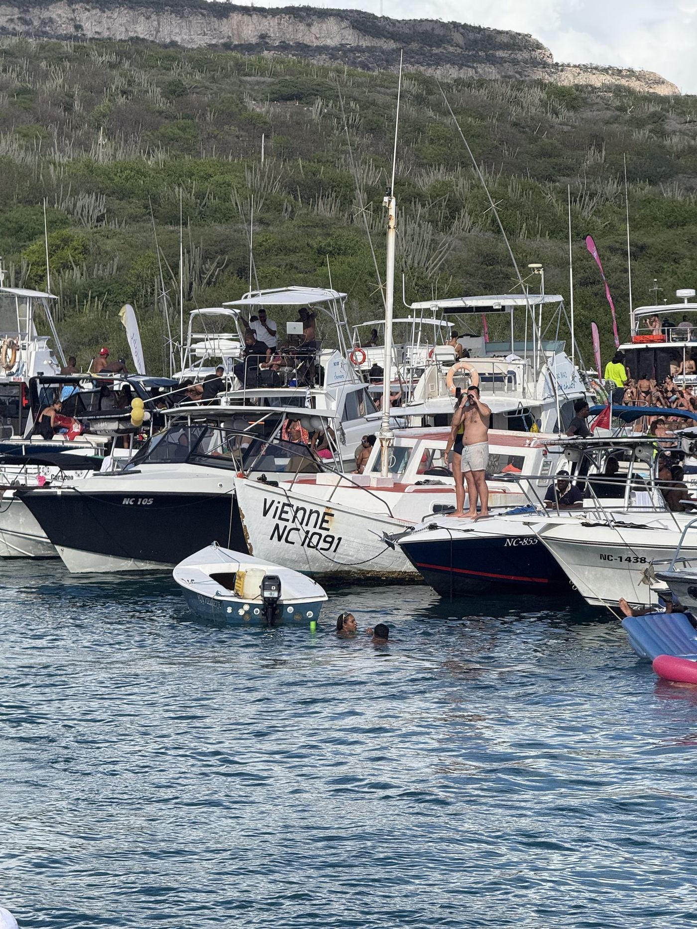 Rafted boats, jet skis and swimmers on inflatables at Fuik Bay on a Sunday