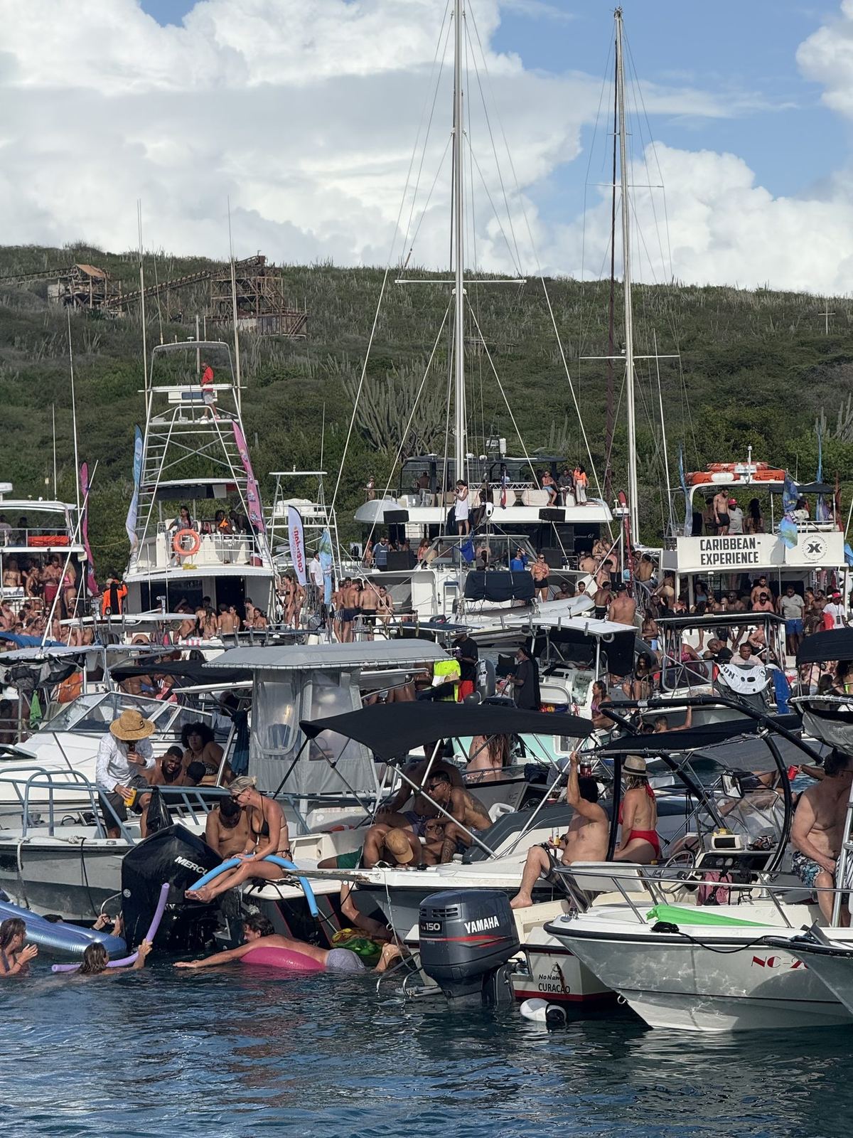 Tenders and swimmers moving between boats at Fuik Bay
